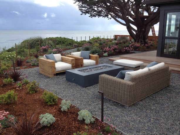 long rectangle fire pit in a pea gravel patio in a coastal style