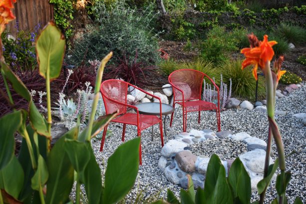 mixing black and white pea gravel with a round fire pit made of concrete that mimics rock