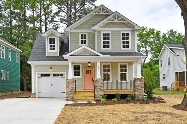 muted green siding as a canvas for a peach-colored front door