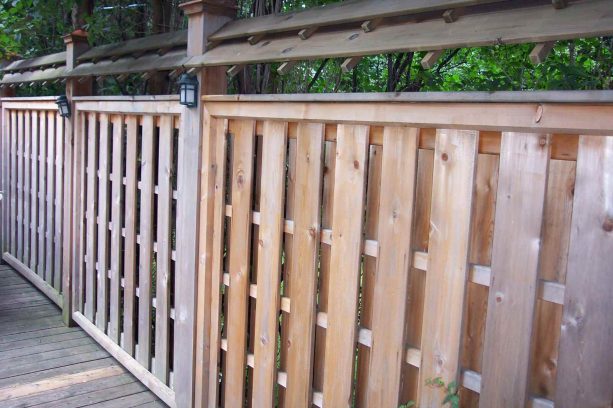 outdoor wall light mounted at the posts of the wood fence
