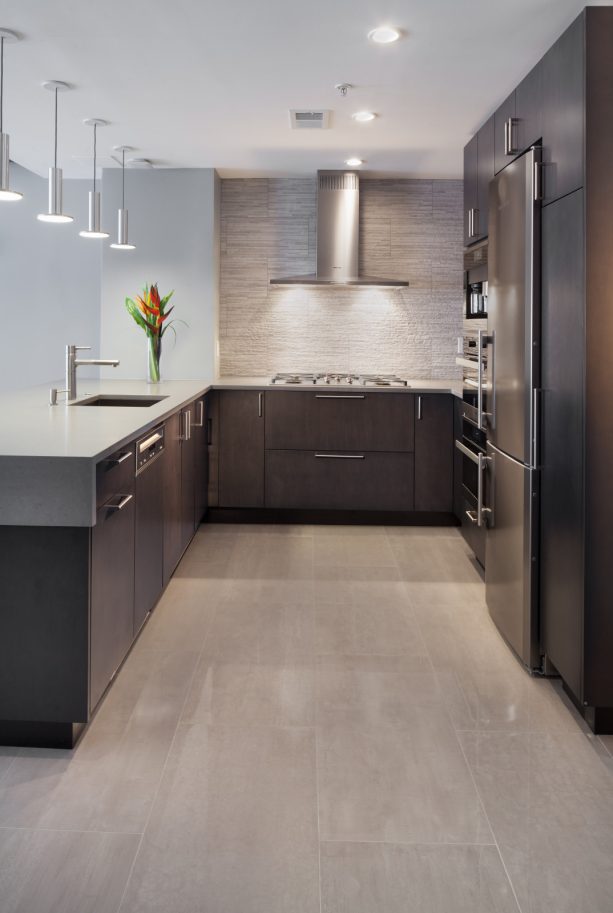 polished kitchen with a combination of dark brown cabinets and gray backsplash