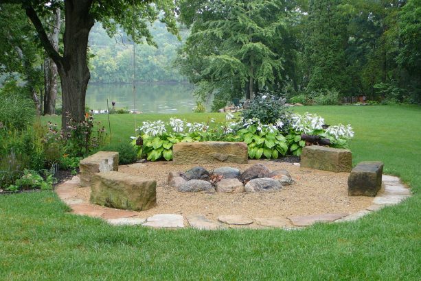 rustic pea gravel area with rocks around the fire pit