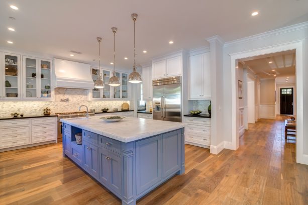 sky blue island cabinet as a focal point in the center of white perimeter cabinets