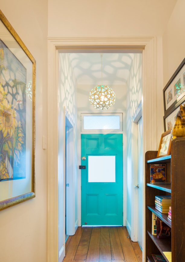 small beach style hallway with a single door in a bold turquoise color