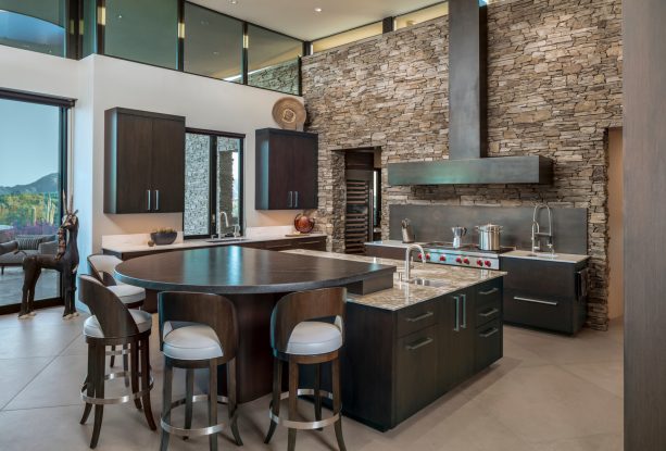 trendy kitchen with dark brown cabinets and black steel backsplash