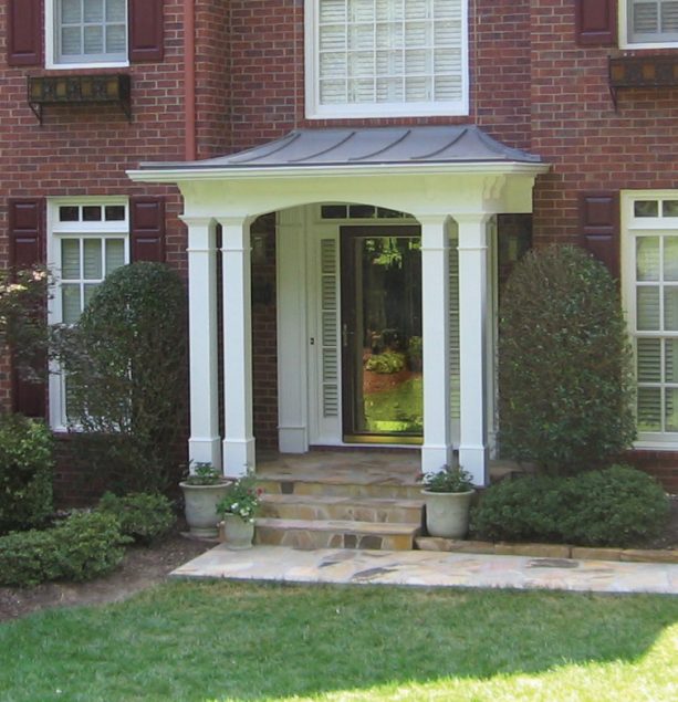 an arched portico with a glass front door and four elegant columns