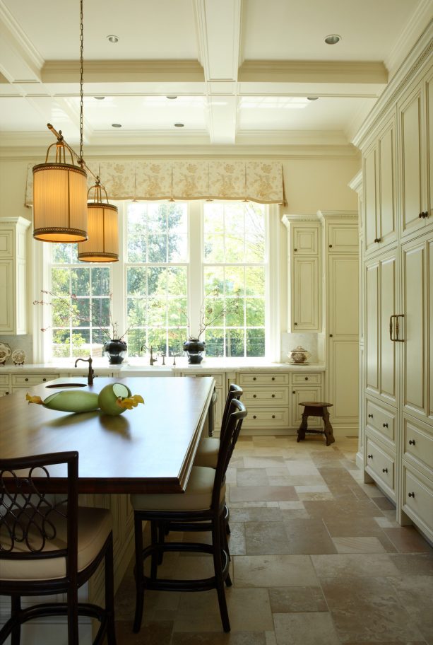 antique limestone floor tile combined with white cabinets to maintain a traditional look