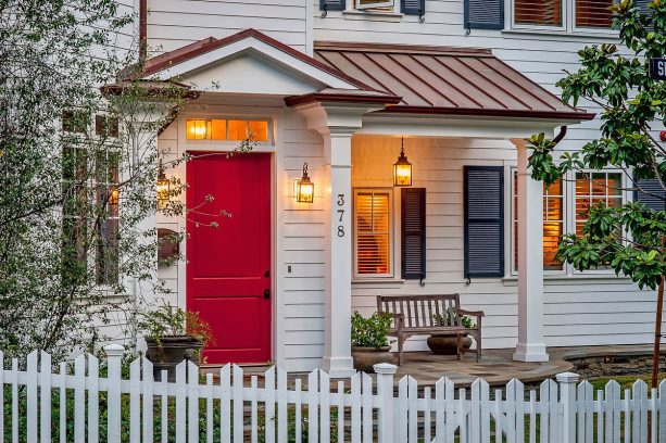 bright red front door with a small portico connected to the porch