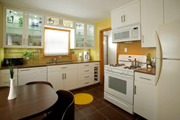 ceramic floor tile in dark brown color with yellow accent combined with white cabinets to maintain an eclectic look