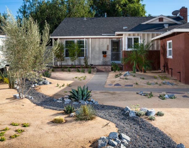 desert-like grassless front yard with dry river bed through the center