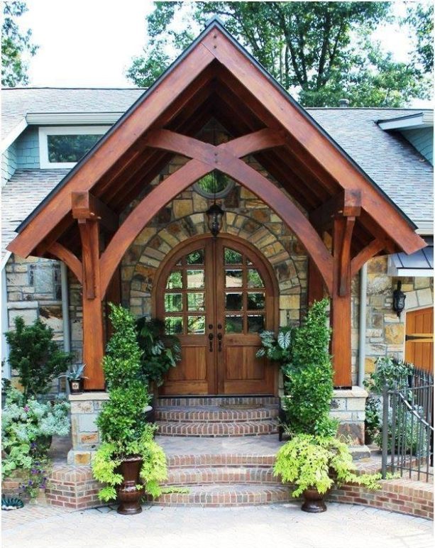 rustic styled front door portico made of wood with a stone wall