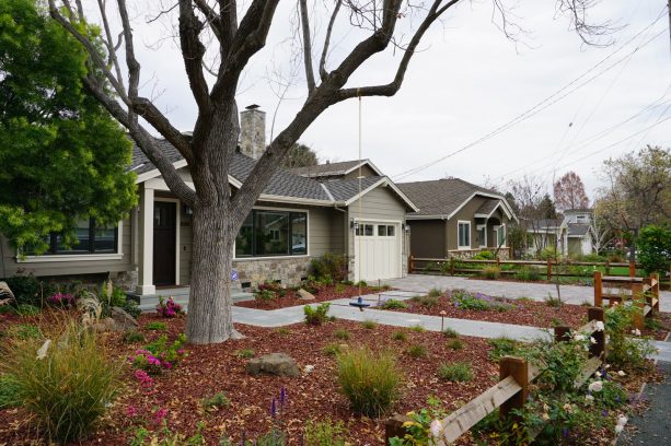 simple and low maintenance grassless front yard with paver path surrounded by mulch