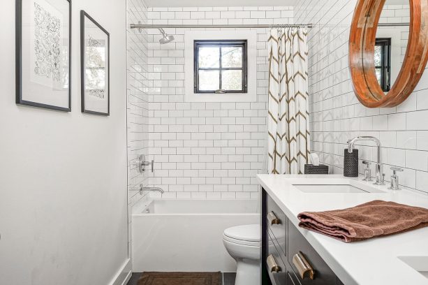 small square shaped black window with polished white trim that blends to the sleek subway tile