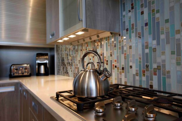 white laminate countertop with custom glass tile hand-assembled backsplash