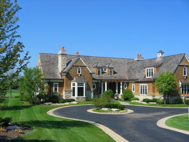 asphalt circular driveway edged with paver and an evergreen landscaping as a center point