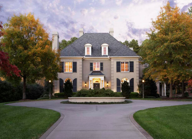 beige-colored stone to frame the planter bed landscaping in a circular driveway