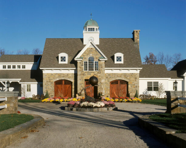 colorful flowering plants around a whimsical decoration in a circular driveway landscaping