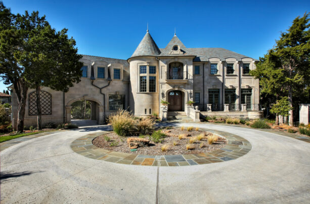 desert landscaping is edged by travertine in a circular driveway