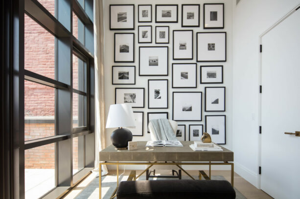 floor to ceiling monochrome framed artworks as an office accent wall