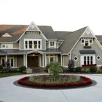 gray concrete circular driveway with a brightly colored landscape in the center