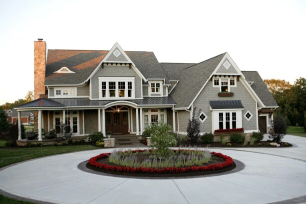 gray concrete circular driveway with a brightly colored landscape in the center