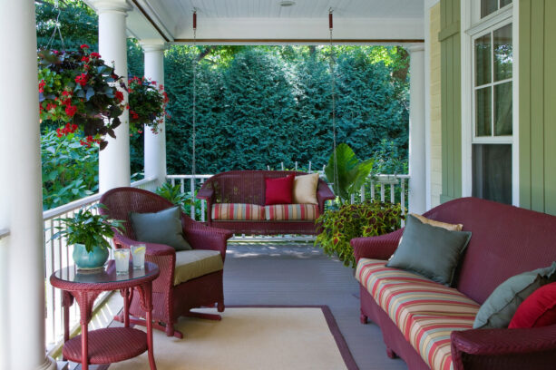 maroon seating on a front porch with gray floor and green siding