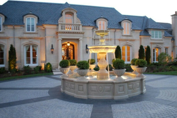 mediterranean landscaping with carved natural stone lion fountain in a circular driveway
