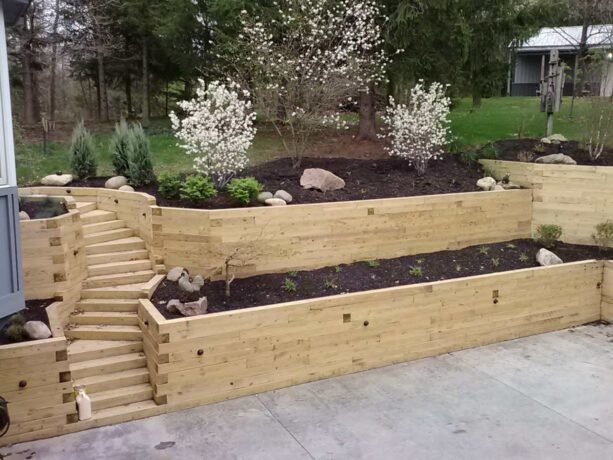 mountain styled landscape with light tone wood tiered retaining wall