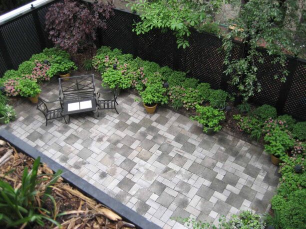 paver block townhouse backyard patio surrounded by lattice screen fence