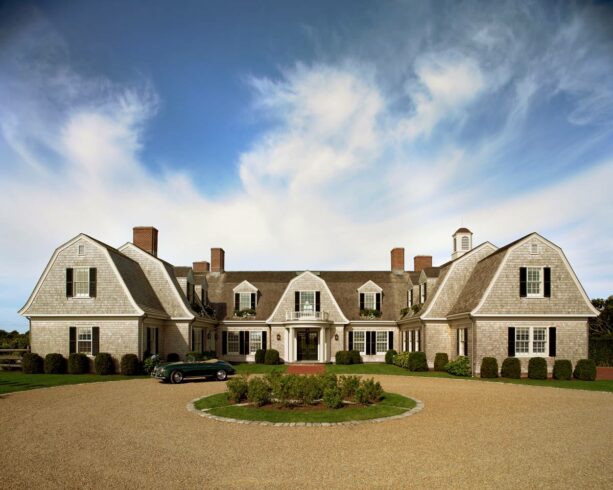 small shrubs are landscaped in a gravel circular driveway