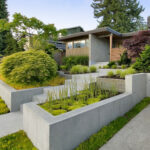smooth surface poured concrete tiered retaining wall with a staircase in the middle