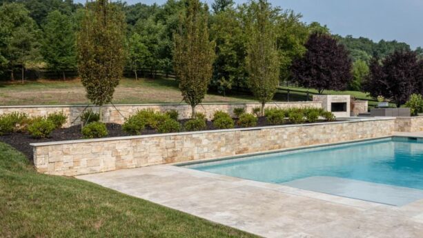 stone veneer tiered retaining wall in a stunning swimming pool area