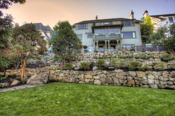 tiered retaining wall made of heavy boulders with a natural stone walkway