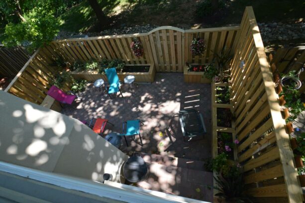 wooden fence and built-in planter boxes in a townhouse backyard with colorful furniture