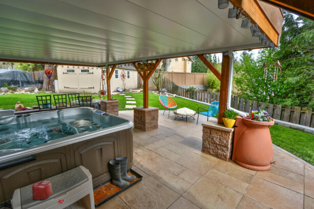 stamped concrete under deck patio with a hot tub