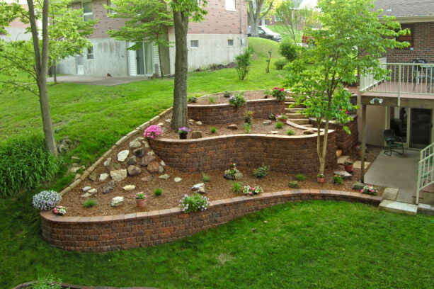 tumbled maytrx block retaining walls in rustic low-maintenance hillside landscaping