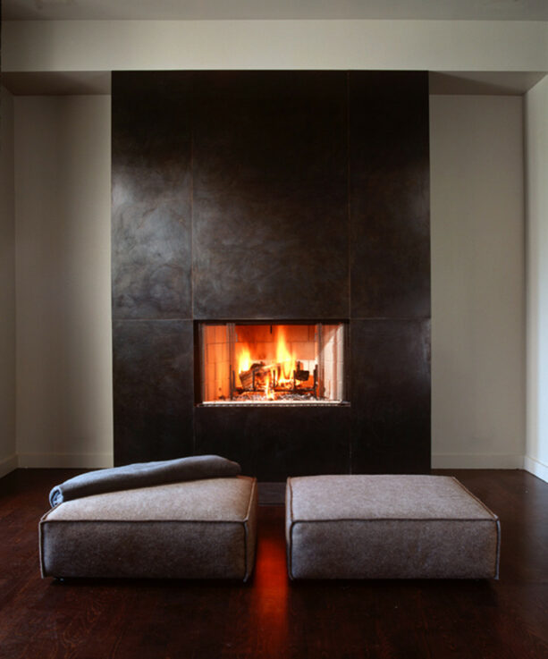a simple fireplace without a mantle surrounded by steel plates