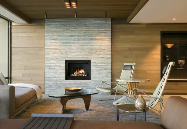 a square-shaped fireplace without a mantle surrounded by travertine stone