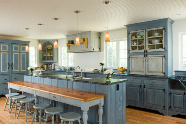 blue galley kitchen with a wooden breakfast bar
