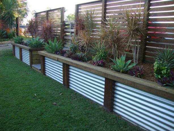 corrugated metal retaining wall with slatted wooden fence in the back