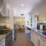 enclosed galley kitchen with a tiny breakfast bar at the island’s extension