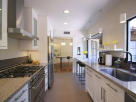 enclosed galley kitchen with a tiny breakfast bar at the island’s extension