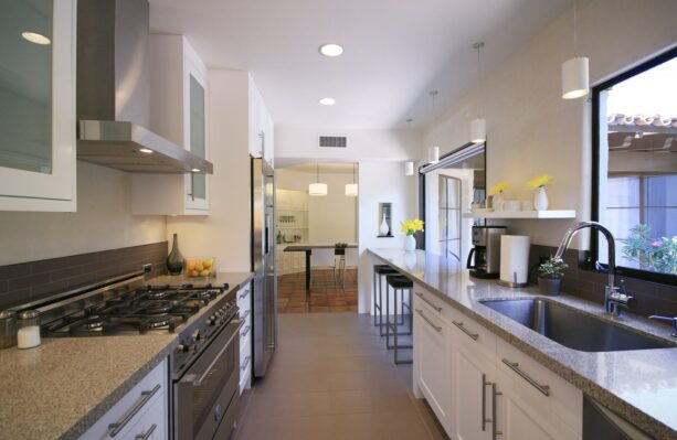 enclosed galley kitchen with a tiny breakfast bar at the island’s extension