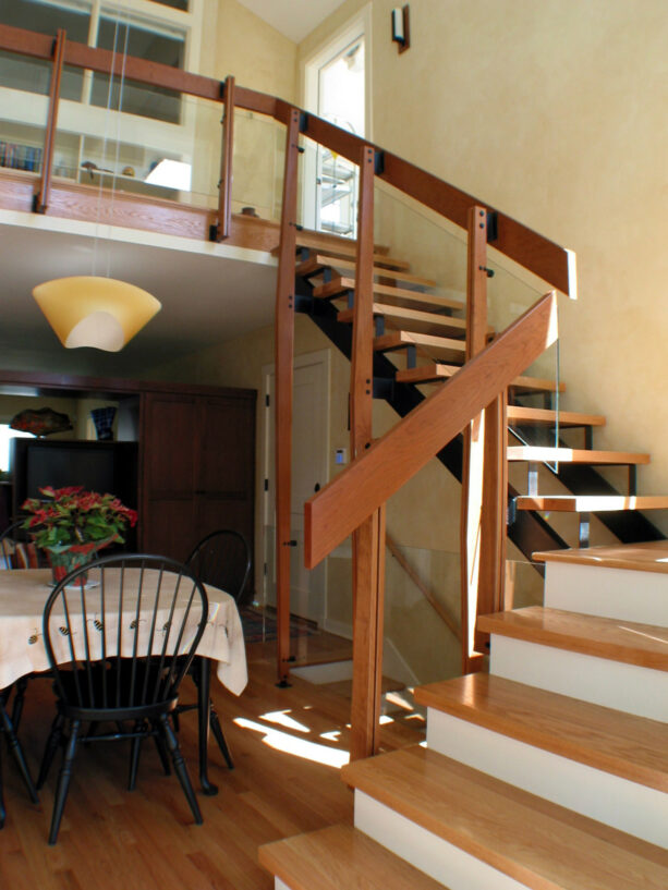 glass half wall stair railing framed with wood
