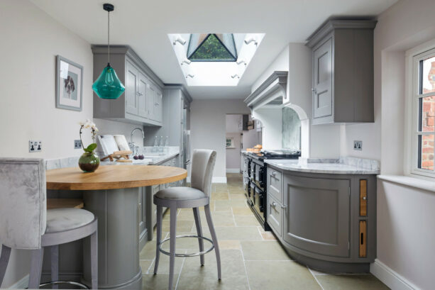 gray galley kitchen with an attached round table as a breakfast bar
