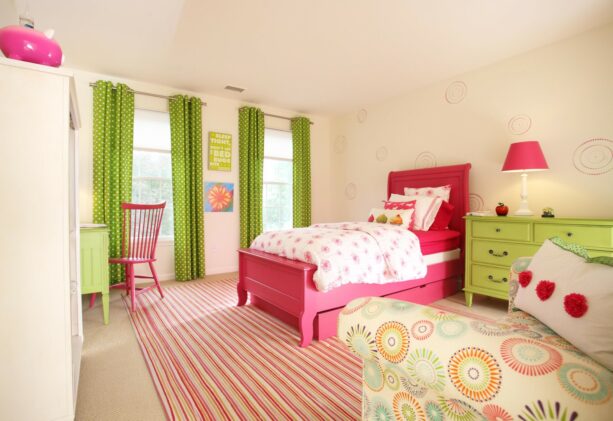 kids’ bedroom with green drapery and furniture juxtaposed with a pink bed