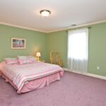 pale mint green wall with pink duvet and carpet in a traditional bedroom