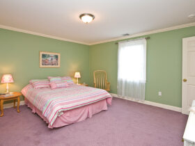 pale mint green wall with pink duvet and carpet in a traditional bedroom