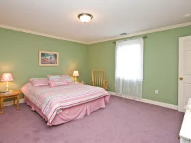 pale mint green wall with pink duvet and carpet in a traditional bedroom