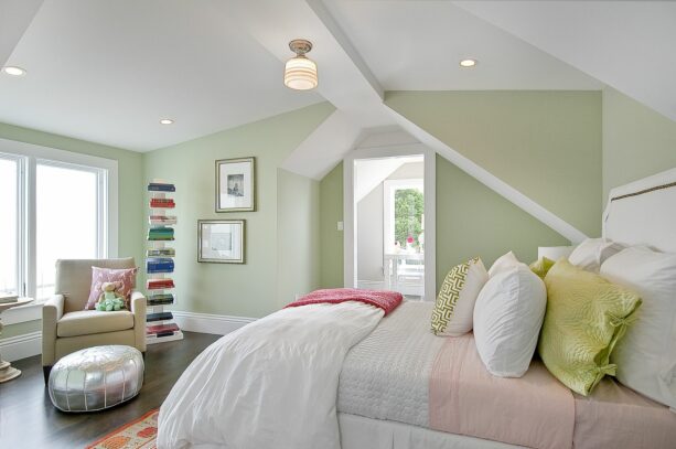 traditional bedroom with muted green wall and pillows accentuated with s soft pink sheet